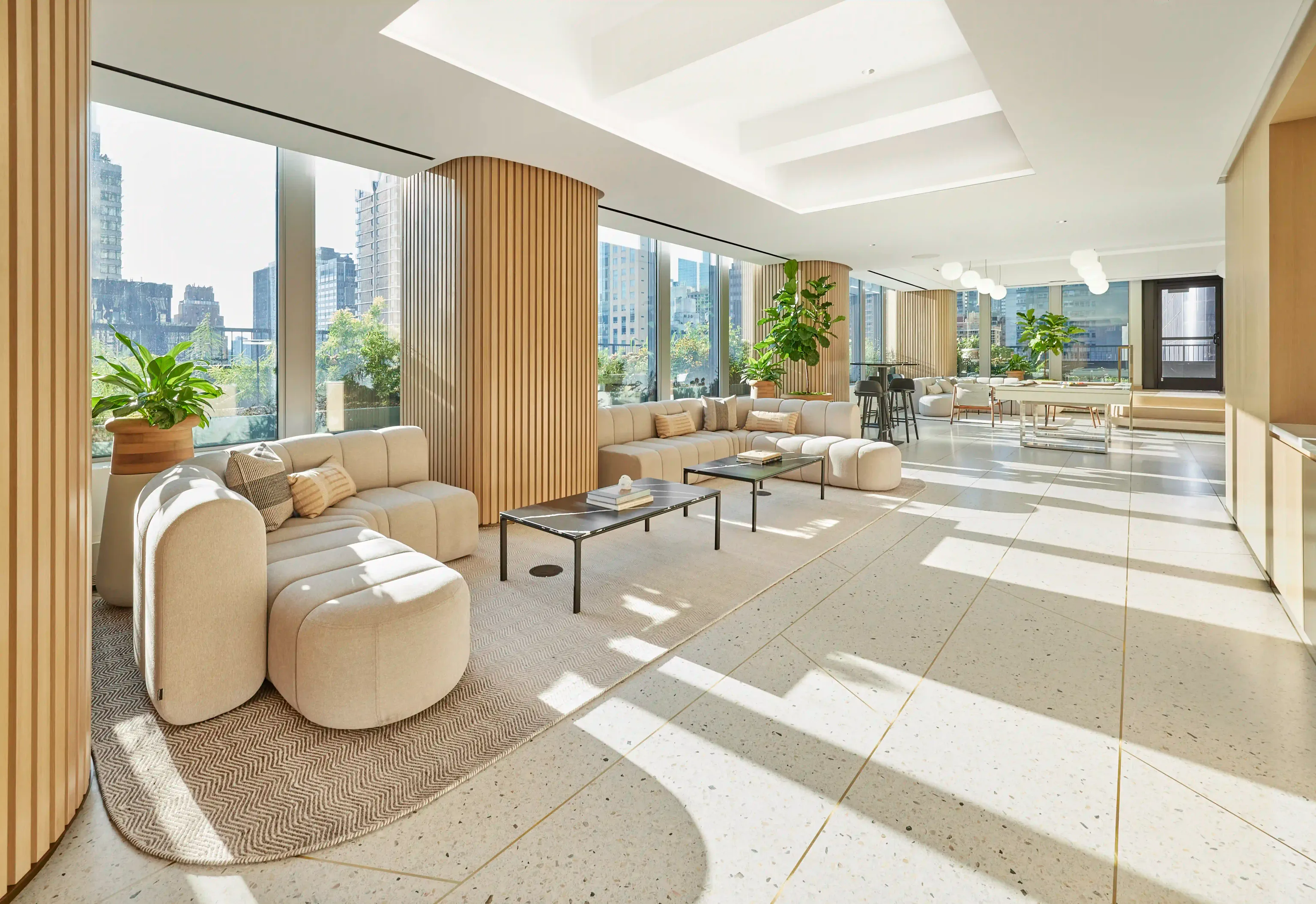 Contemporary lounge and dining area with expansive windows showcasing cityscape.