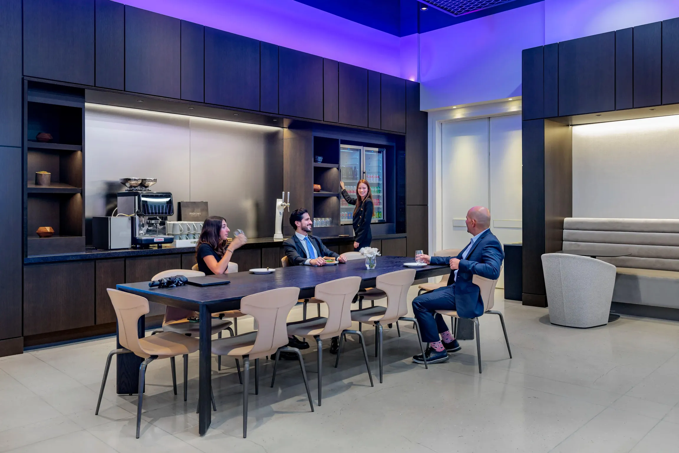 A diverse group of professionals sitting around a table in a contemporary office, engaged in a meeting.