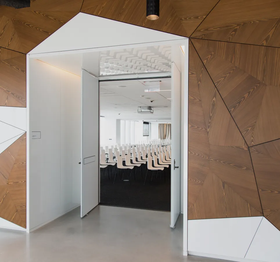 Entrance to a conference room with white chairs and a large windows.
