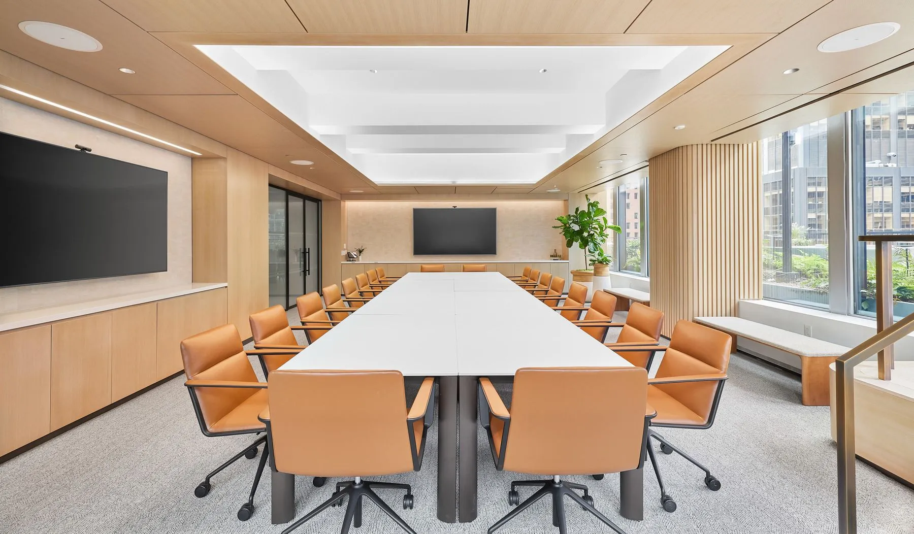 825 Third Ave's modern conference room with white table and vibrant orange chairs.