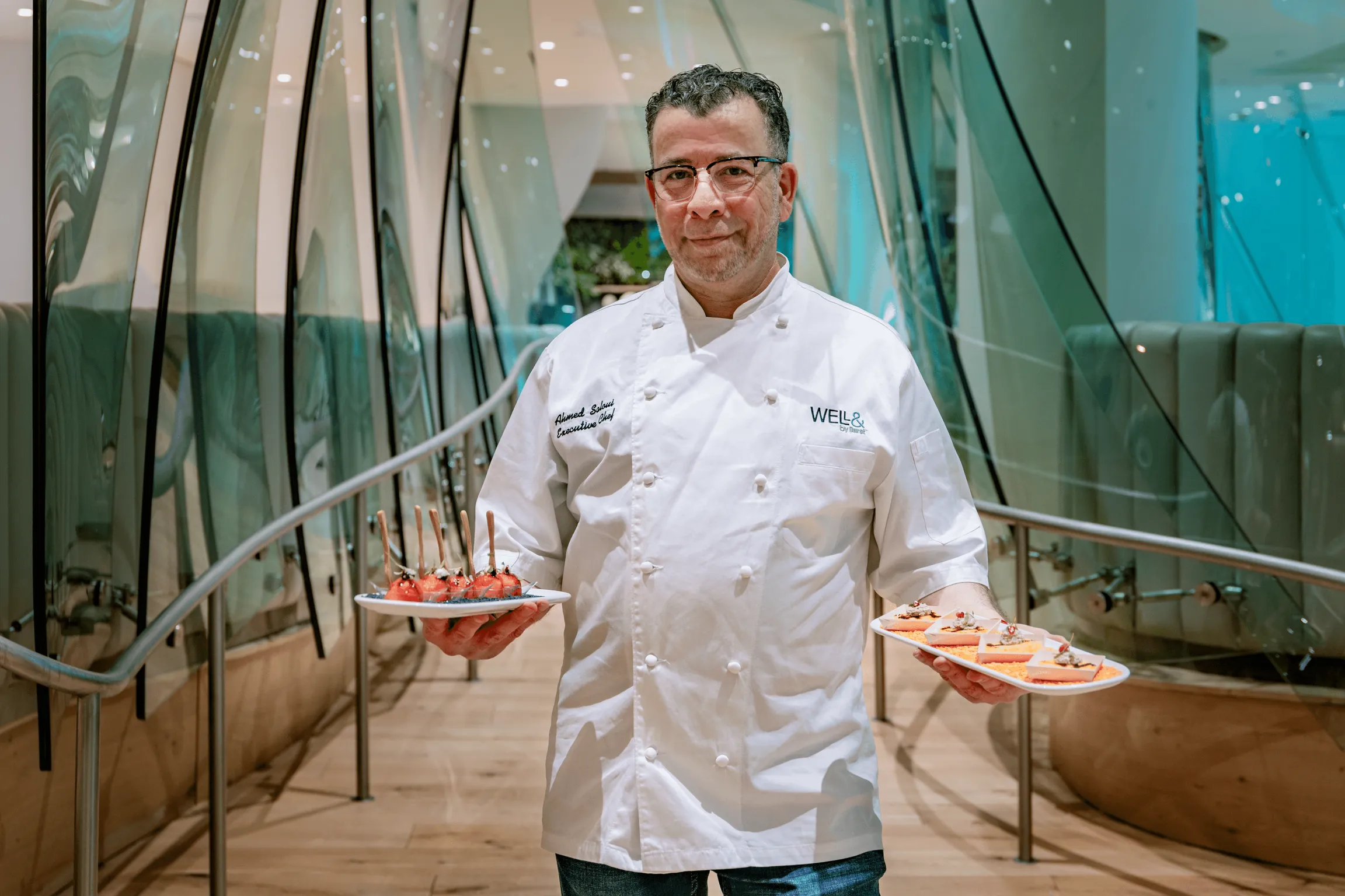Chef displaying a variety of appetizing dishes on plates.