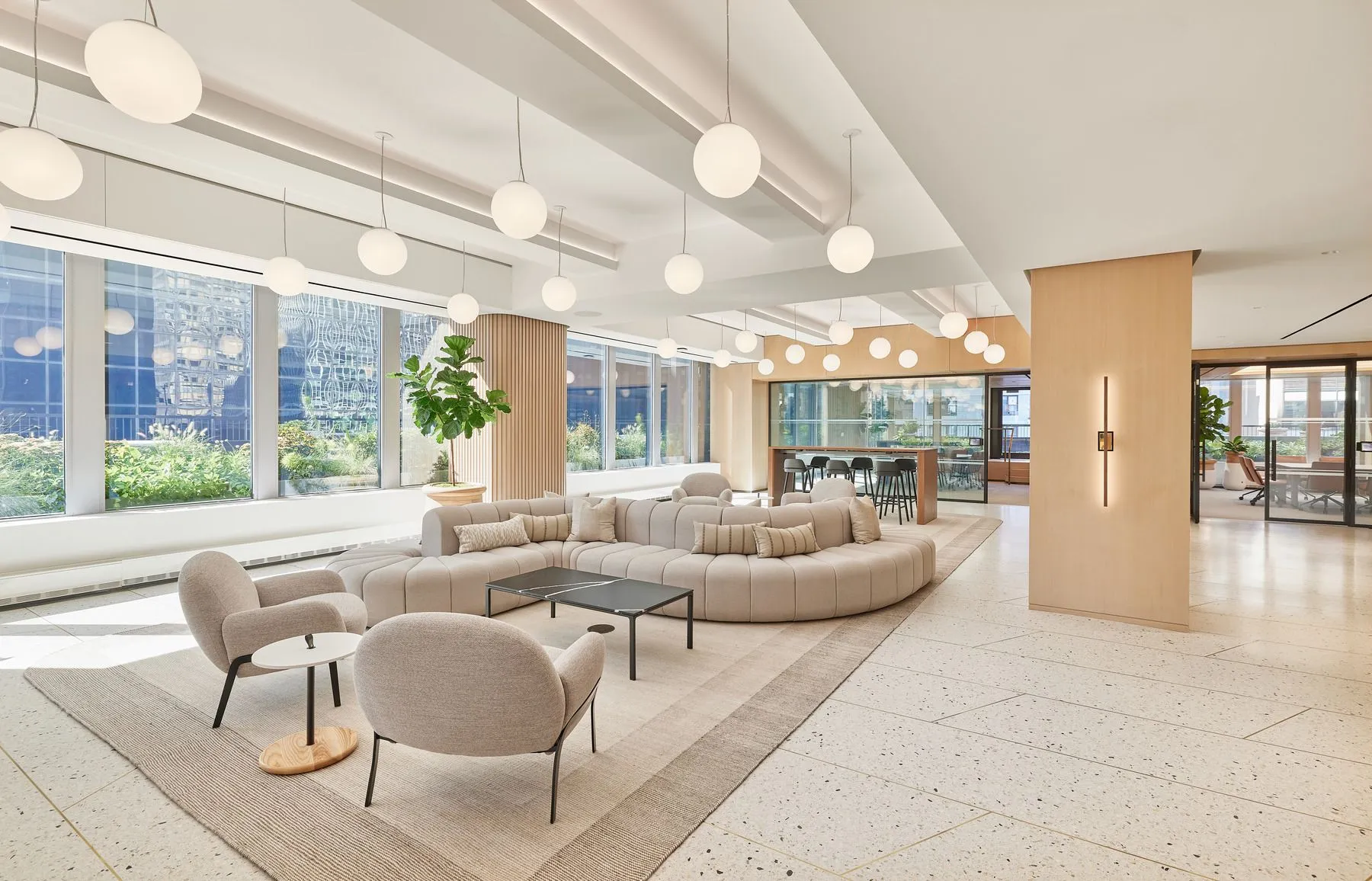 A modern office lobby with white furniture and large windows.