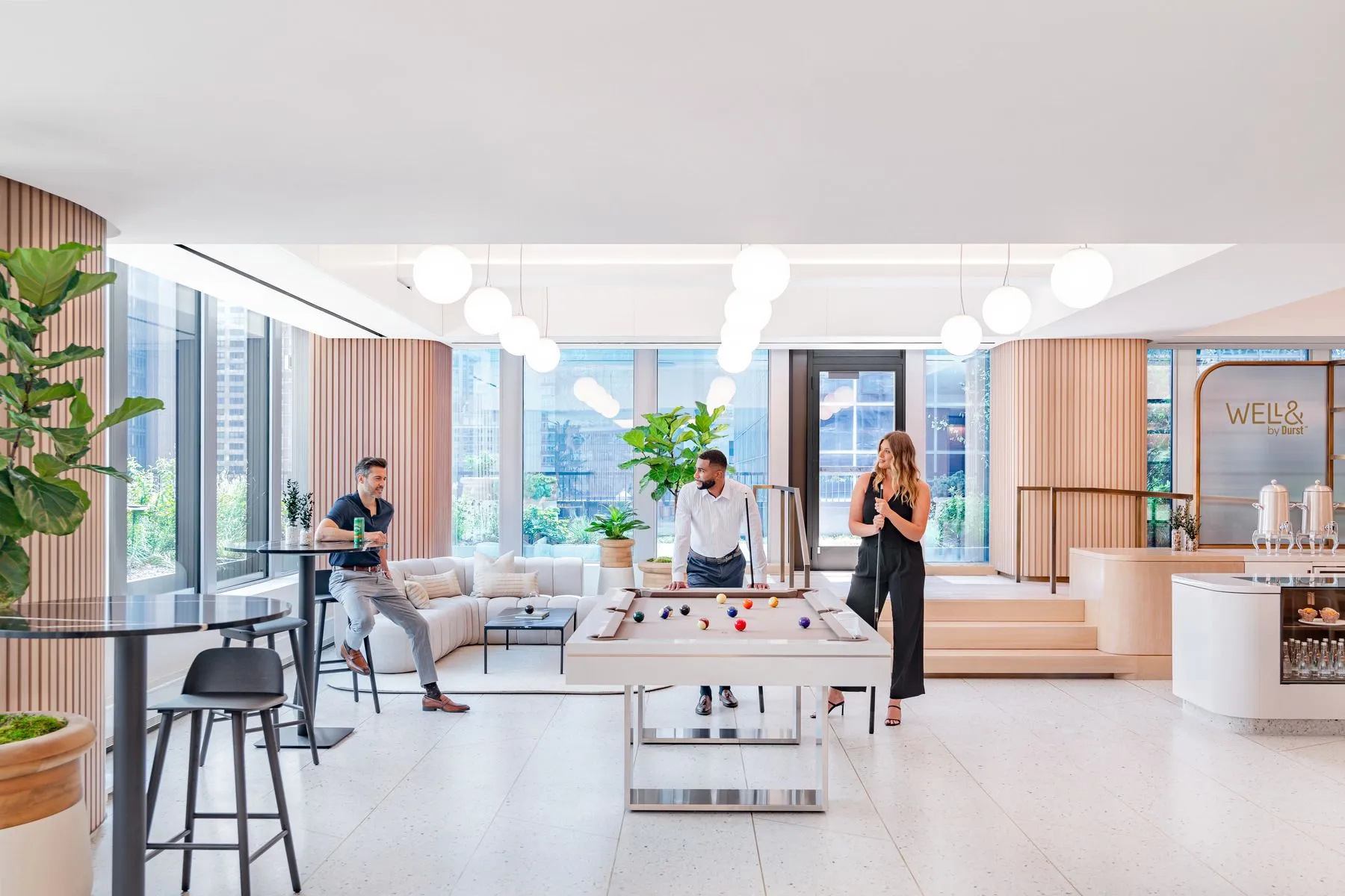 People socializing and playing billiards in a lavish game room located on the 12th floor of 825 Third Avenue. 
