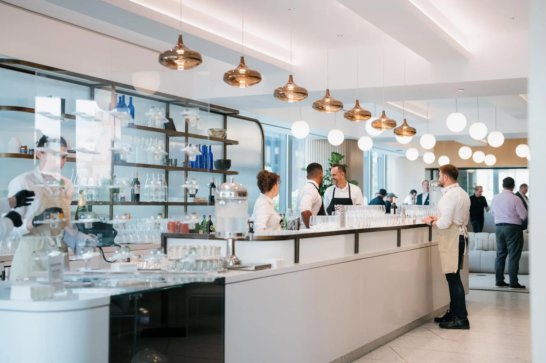 Modern Café & Cocktail Bar featuring a lengthy counter and the Well& by Durst logo on the wall during a corporate event
