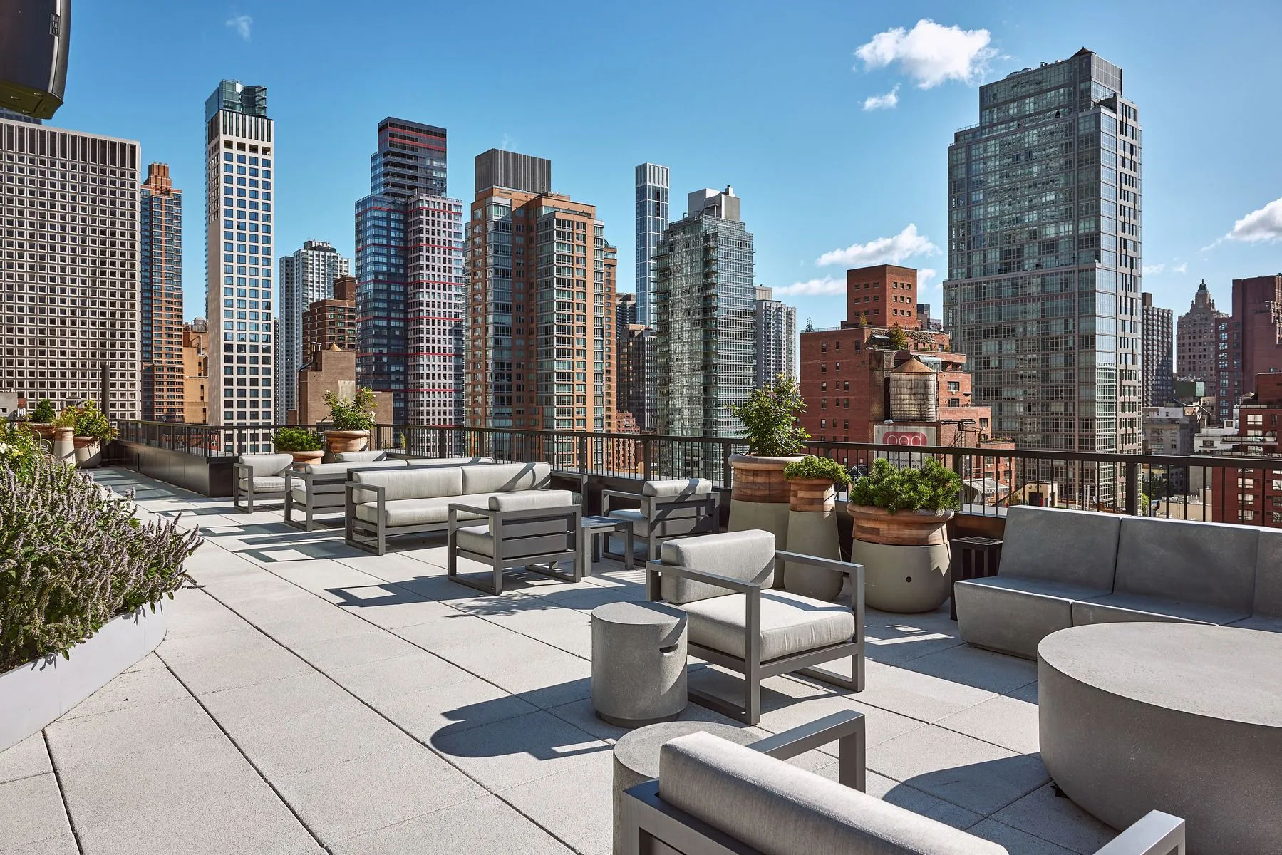 A modern rooftop terrace with benches, offering a view of New York's skyline. Located at 825 Third Ave's 12th floor.