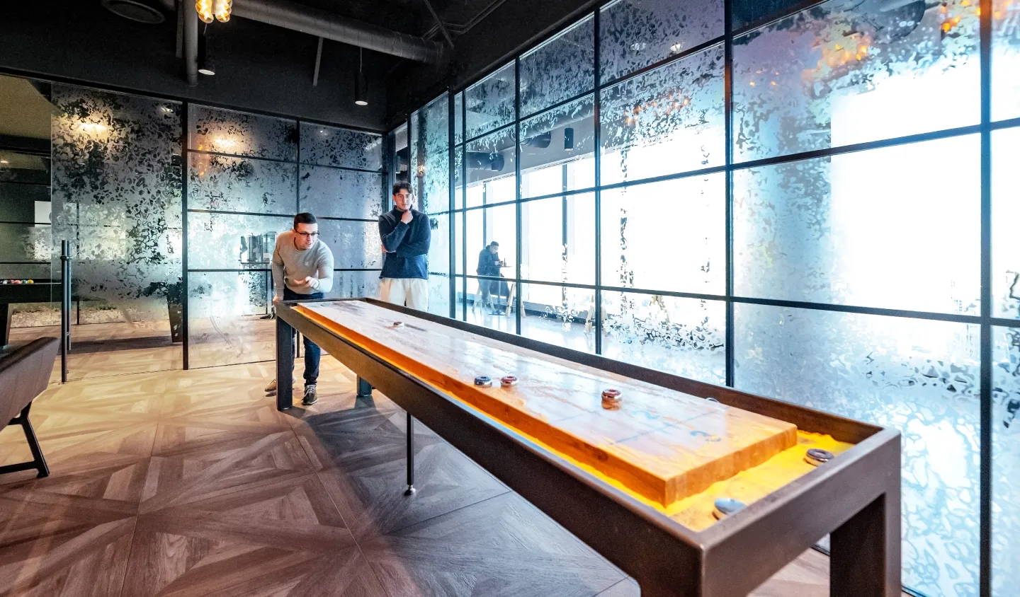 Interior of modern office building lobby with sleek design and panoramic cityscape view through glass windows.